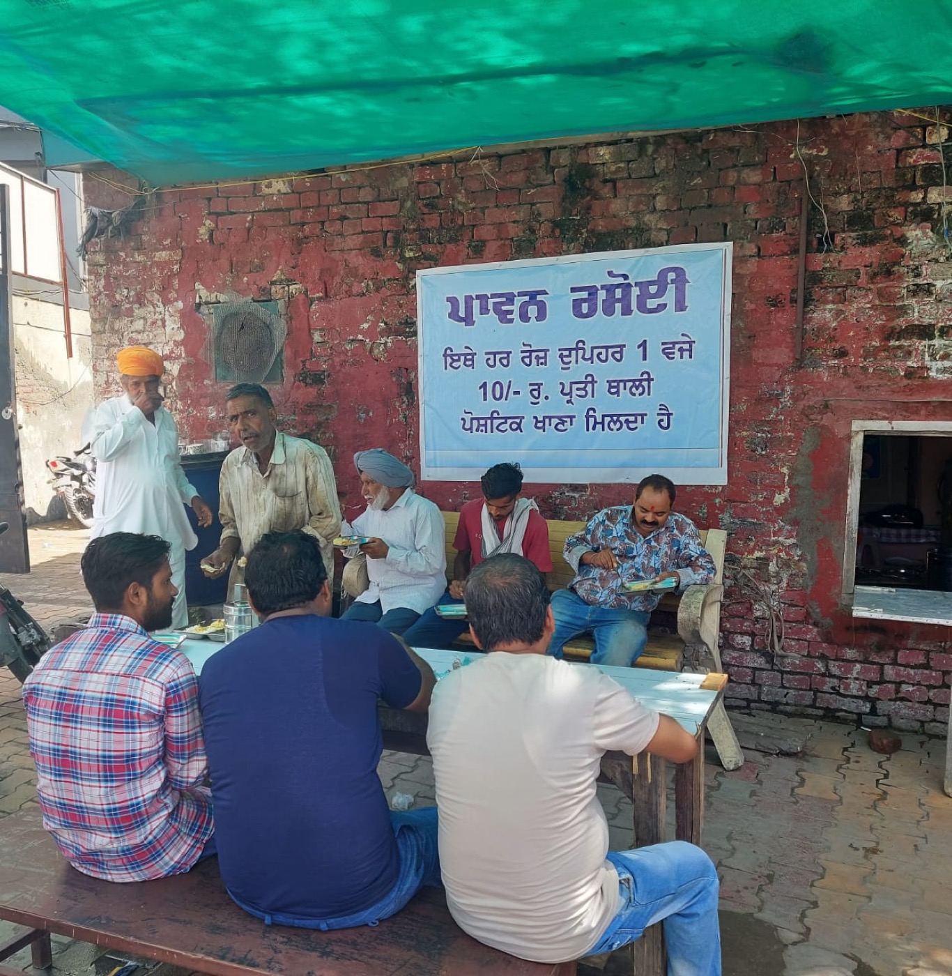 Beneficiaries seated and eating at Paavan Rasoi