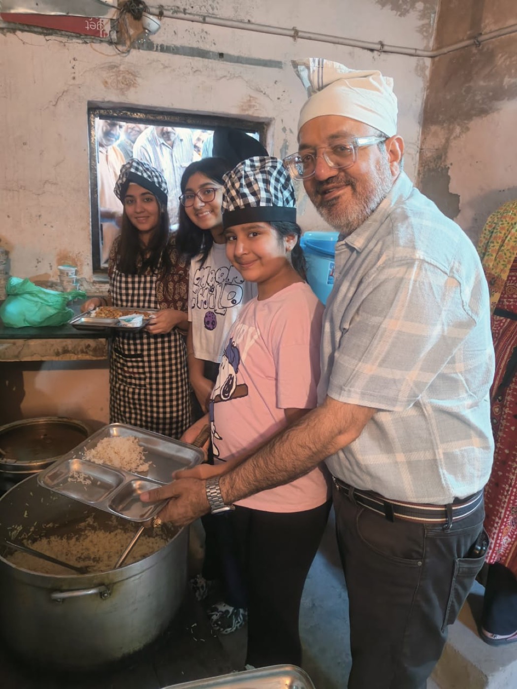 Volunteers serving rice from a large pot